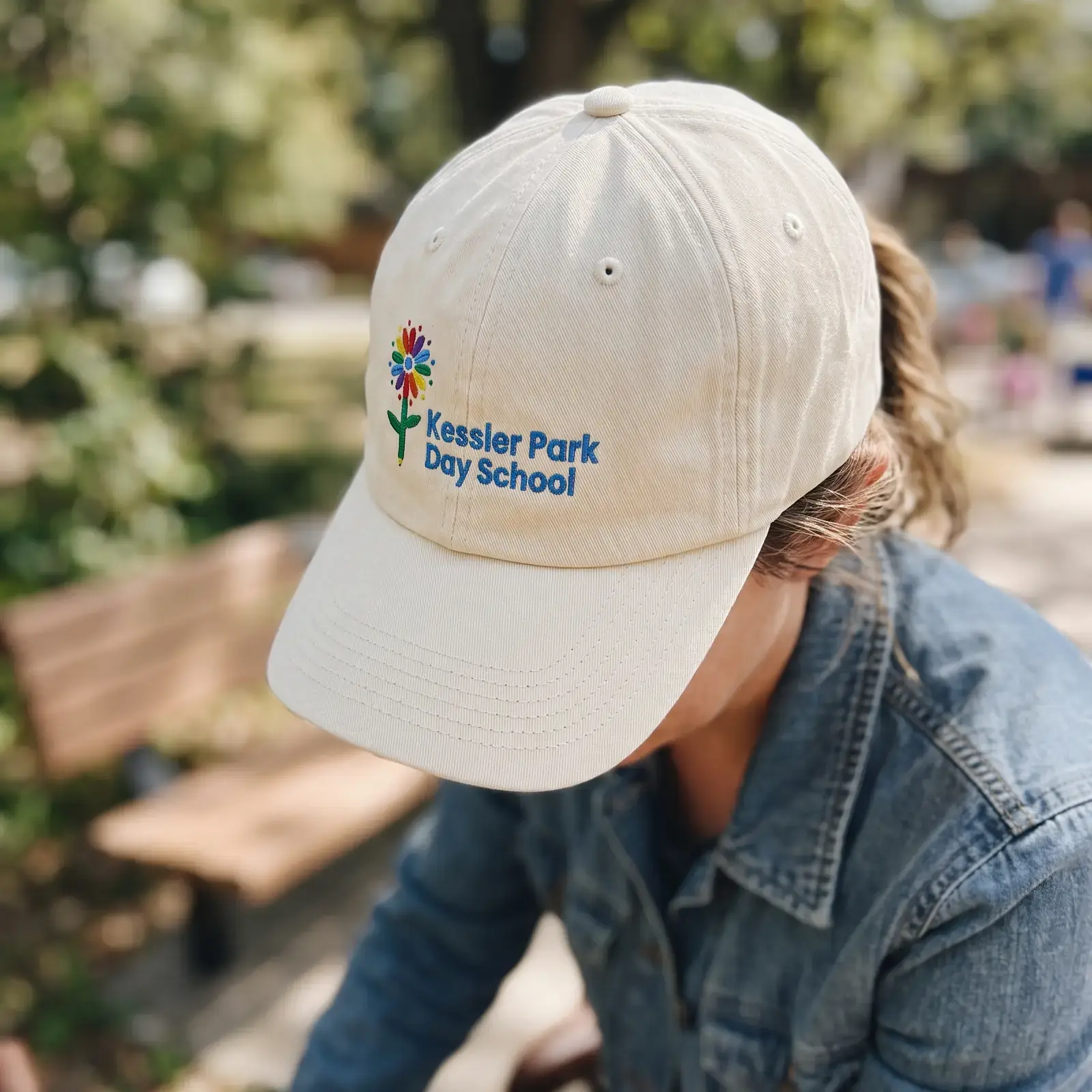 Cream hat with the embroidered KPDS flower logo